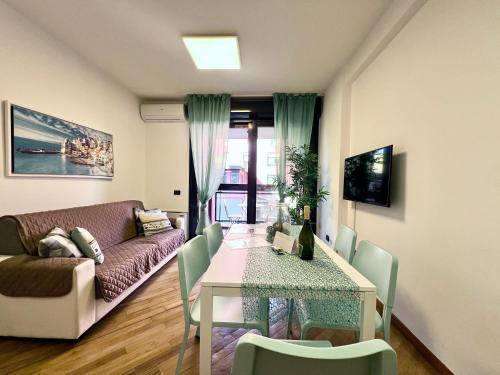 een woonkamer met een tafel en een bank bij DOCK OF THE BAY GENOVA, Stylish Apartment in the Heart of Genoa with Air Conditioning, Private free Garage, Harbour View, extra garage at 25,00 euro per night on request, Welcome kit Priority with Prosecco in Genua