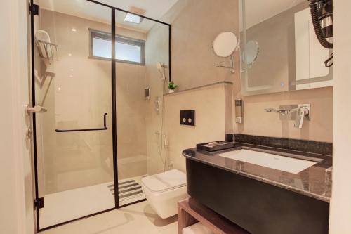 a bathroom with a shower and a sink and a toilet at Hotel Urban chant in Rishīkesh