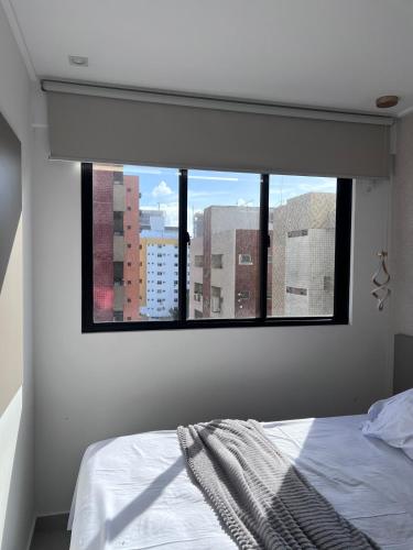 a bedroom with a window with a view of a city at Studio Design 3 Lions in Maceió