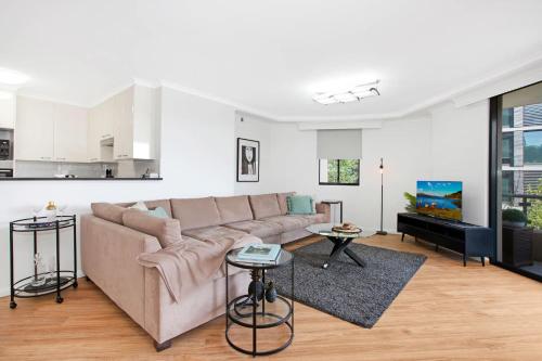 a living room with a couch and a kitchen at Pyrmont 2 Bed Apartment - Prime Location w parking in Sydney