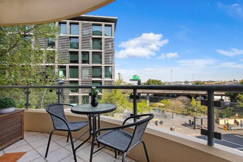 a balcony with a table and chairs and a view of a city at Pyrmont 2 Bed Apartment - Prime Location w parking in Sydney