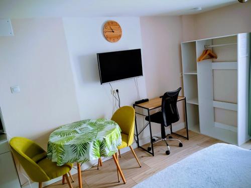 a room with a desk and chairs and a television at Studio cosy, tout équipé, WI-FI proche Clinique Saint-Pierre in Perpignan