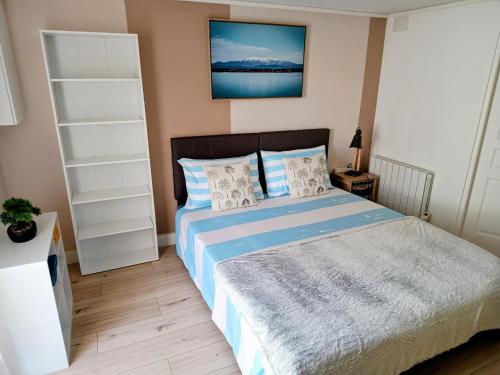 a bedroom with a bed with blue sheets and pillows at Studio cosy, tout équipé, WI-FI proche Clinique Saint-Pierre in Perpignan