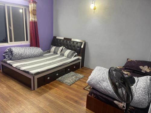 a small bedroom with a bed and a window at Aanshi homestay in Nagarkot