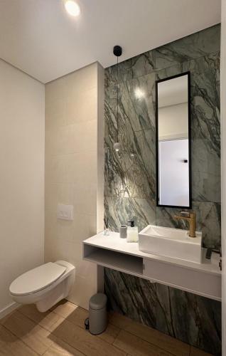 a bathroom with a sink and a toilet and a mirror at Casa dos Camilos - Douro View Terrace House in Peso da Régua