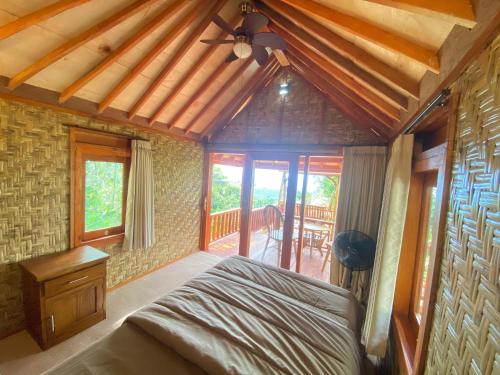 Lajolla Waterfall Resort في Luk: غرفة نوم بها سرير وسقف خشبي