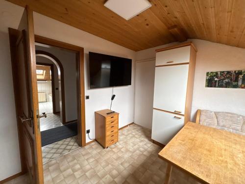 a room with a bed and a tv and a door at Danner Appartements Regau - Möblierte Langzeit- & Monteurapartments nahe Gmunden, Laakirchen, Salzburg & Wels I Vollmöbliert & mit Parkplatz in Rutzenmoos