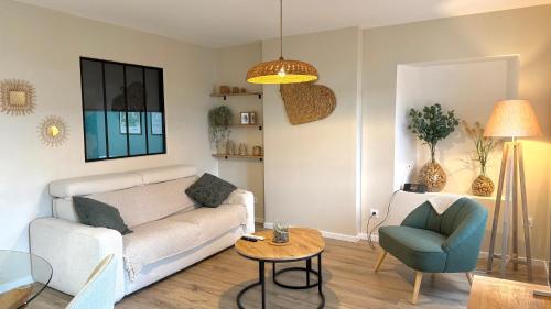 a living room with a couch and a chair and a table at Le Gingko in Montmerle Sur Saône