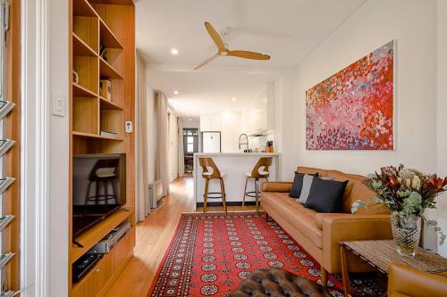 a living room with a couch and a table at Charming 3-Bedroom Terrace in the Heart of Glebe in Sydney