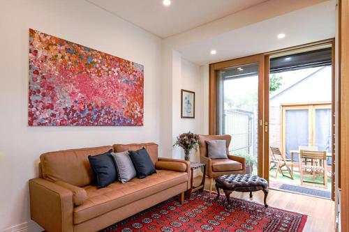a living room with a couch and a painting on the wall at Charming 3-Bedroom Terrace in the Heart of Glebe in Sydney