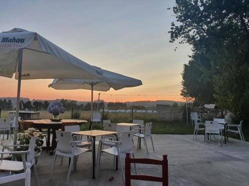a group of tables and chairs with an umbrella at La pallota de san cristobal in Camino