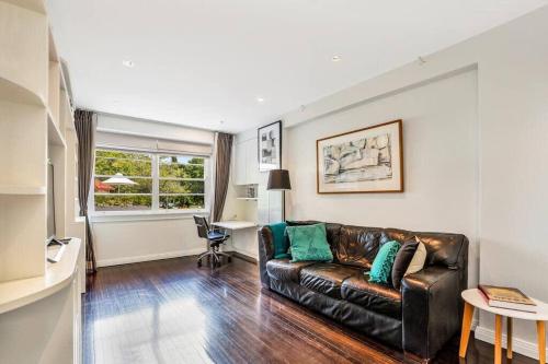 a living room with a leather couch and a desk at Henrietta's Gem - Close to cafes, shops and more in Sydney
