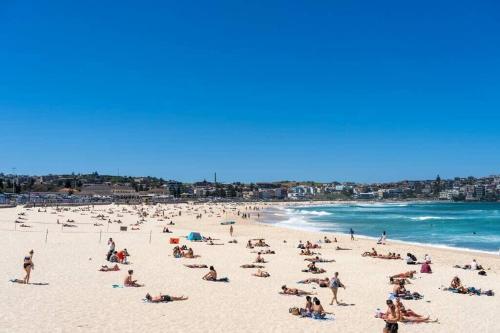 a large group of people on a beach at Edward Escape - Short Walk to Beach in Sydney