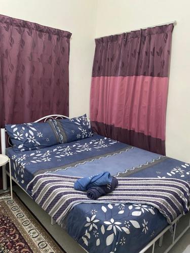 een slaapkamer met een bed met blauwe lakens bij Pinggiran Bayu Homestay in Kuantan