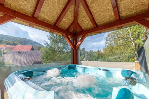 a jacuzzi tub with a view of the mountains at Pool & Wellness Twin Chalets Zavrh in Šimatovo