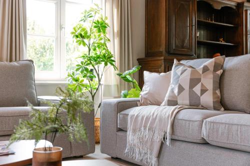 HarelbekeにあるHuswell - Authentic Serene Vacation Hideaway with Pondのリビングルーム(ソファ、植物付)