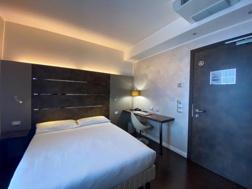 a bedroom with a bed and a desk and a bed sidx sidx sidx at CAVALLO Hotel Noventa di Piave in Noventa di Piave
