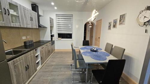 a kitchen and dining room with a table and chairs at Jasmin's House, 3-bedroom entire house in Northampton