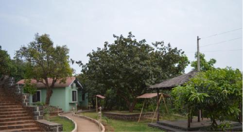 szklarnia z drogą prowadzącą do domu w obiekcie Nirvana Bhimashankar Jungle Resort w mieście Bhimashankar