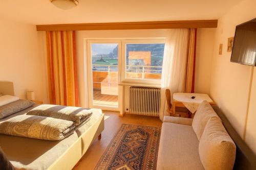 a bedroom with a bed and a large window at Pension Waldegg in Hippach