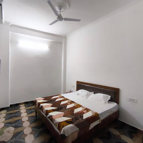 a bedroom with a bed with a ceiling fan at Hotel Shree Hari in Rishīkesh