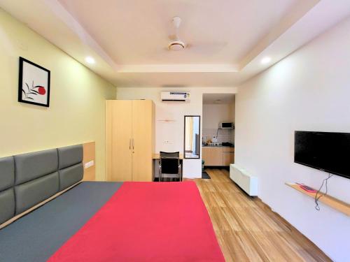 sala de estar con alfombra roja y TV de pantalla plana en Kommune Living, en Gurgaon