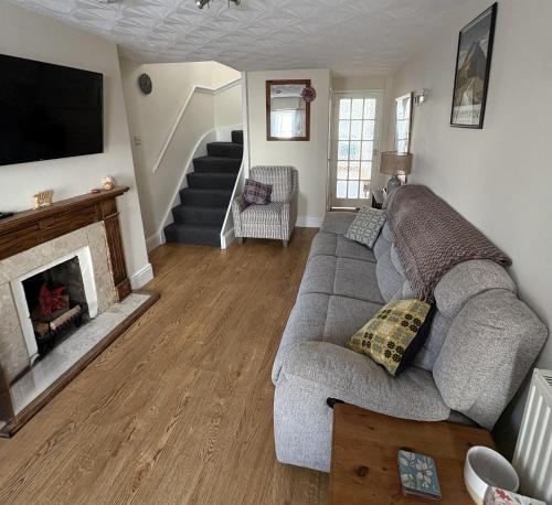 a living room with a couch and a fireplace at Charming 2 bedroom cottage in Brecon - families and pets welcome! in Brecon