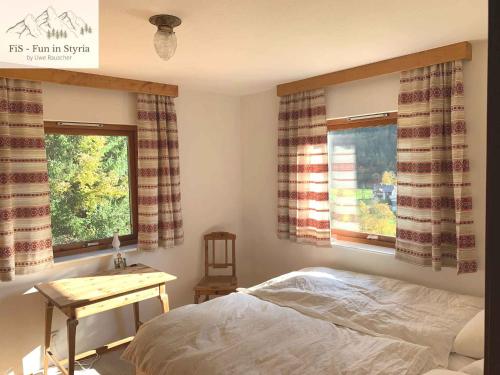 BräuhofHoliday home in Bad Aussee - Steiermark 55006的一间卧室，有一张床、一张书桌和两扇窗户