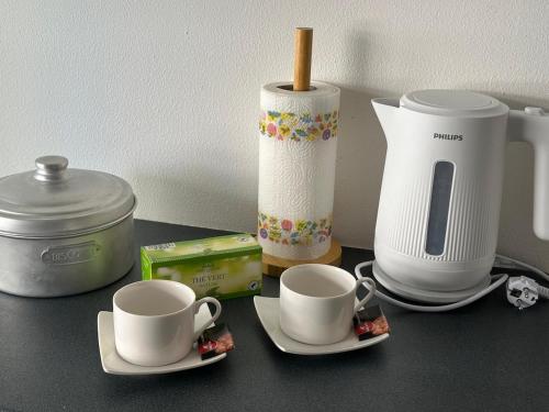 罗克布吕讷-卡普马丹Bright Seaside Studio的柜台上放着两个杯子、碟子和一台咖啡机。