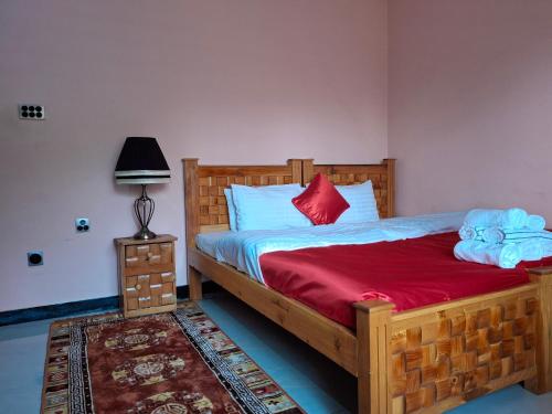 a bedroom with a wooden bed with a red blanket at Sultan Resorts 7 star Luxurious accommodations 