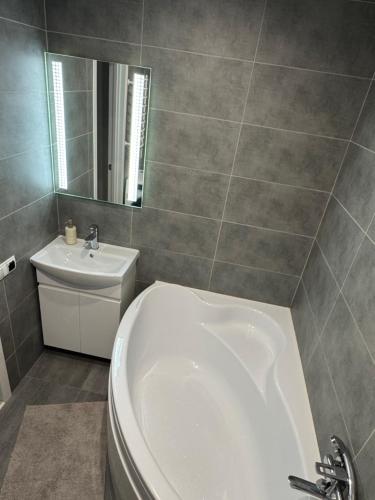 Un baño con bañera blanca y lavabo. en Стильна, затишна, простора квартира в центрі, en Cherkasy