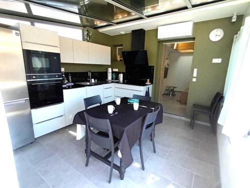 een keuken met een zwarte tafel en stoelen. bij Gite charles in Capbreton