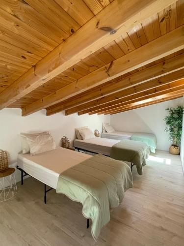 two beds in a room with wooden ceilings at ōku in Monchique
