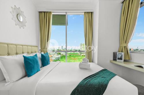 a bedroom with a large bed with a window at Lily by Kozystay - Kuningan in Jakarta