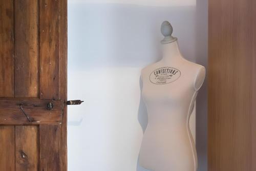 a white mannequin with a sign on it next to a door at Ca' Molinetto in Treviso