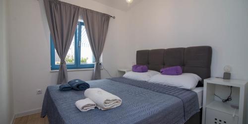 a bedroom with a bed with towels on it at Pinea in Veli Lošinj