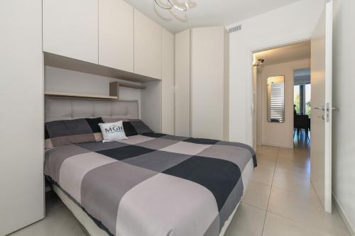 een slaapkamer met een zwart-wit bed en een hal bij MGH- Grace Apartment Katya Resort in Rivoltella