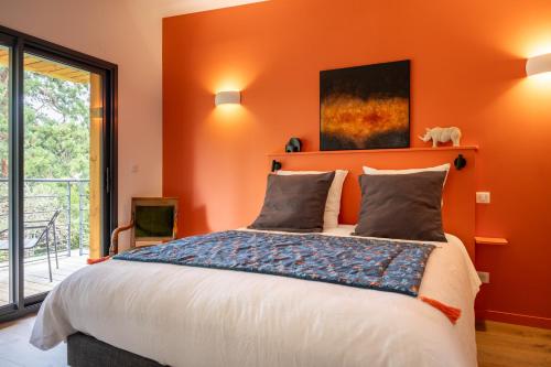 ein Schlafzimmer mit orangefarbenen Wänden und einem großen Bett in der Unterkunft Bread et Couette in Lyon