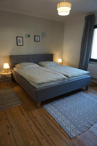 a bedroom with a bed with two lamps on it at Haus am Fluss in Bad Freienwalde