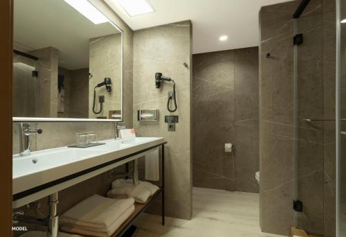 a bathroom with a sink and a shower at Hotel Riu Palace Nautilus - Adults Only in Torremolinos