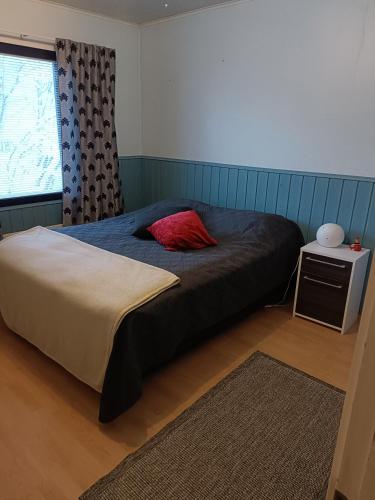 Un dormitorio con una cama con una almohada roja encima. en Sulli apartment, en Rovaniemi
