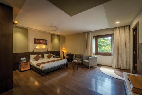una habitación de hotel con una cama y una silla en Lariya Resort, en Jodhpur