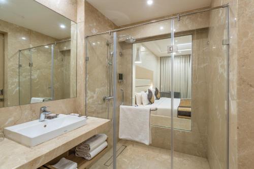 Un baño con lavabo y ducha y una cama. en Lariya Resort, en Jodhpur