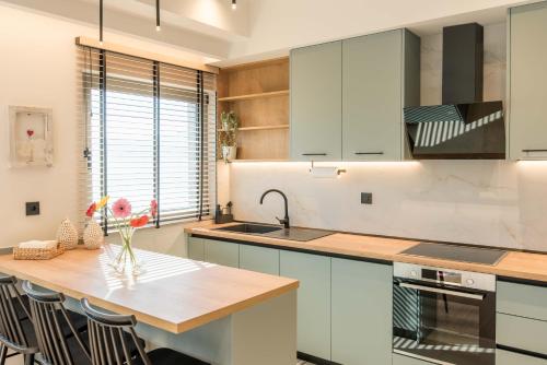 a kitchen with white cabinets and a wooden counter top at Kyveli Lake Suite in Kastoria