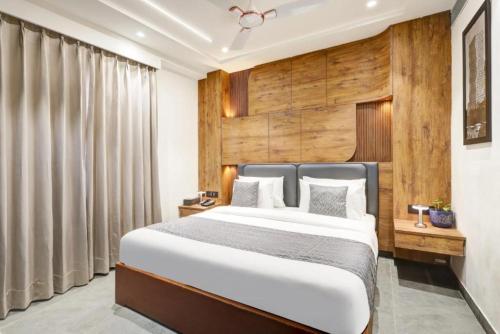 Un dormitorio con una cama y una pared de madera. en Hotel Tyche Inn- Luxury in Central Delhi, Near Connaught Place & New Delhi Station, en Nueva Delhi
