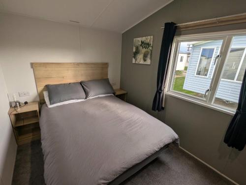 Una cama o camas en una habitación de Lyons Robin Hood Deluxe Caravan