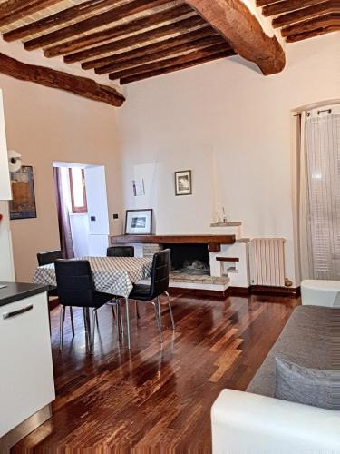 a living room with a table and a fireplace at Appartamenti San Salvatore 1 by Ospitaci in Foligno