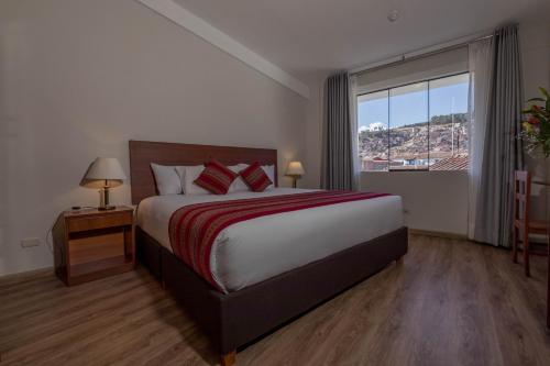 a bedroom with a large bed and a large window at Quechua Plaza Hotel in Cusco