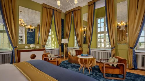 a bedroom with a bed and a table and chairs at Hotel Taschenbergpalais Kempinski in Dresden