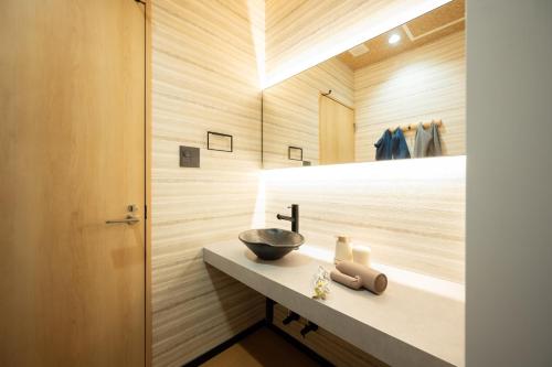 a bathroom with a sink and a mirror at 一棟貸切サウナ付き宿 我忘歳月 清風明月